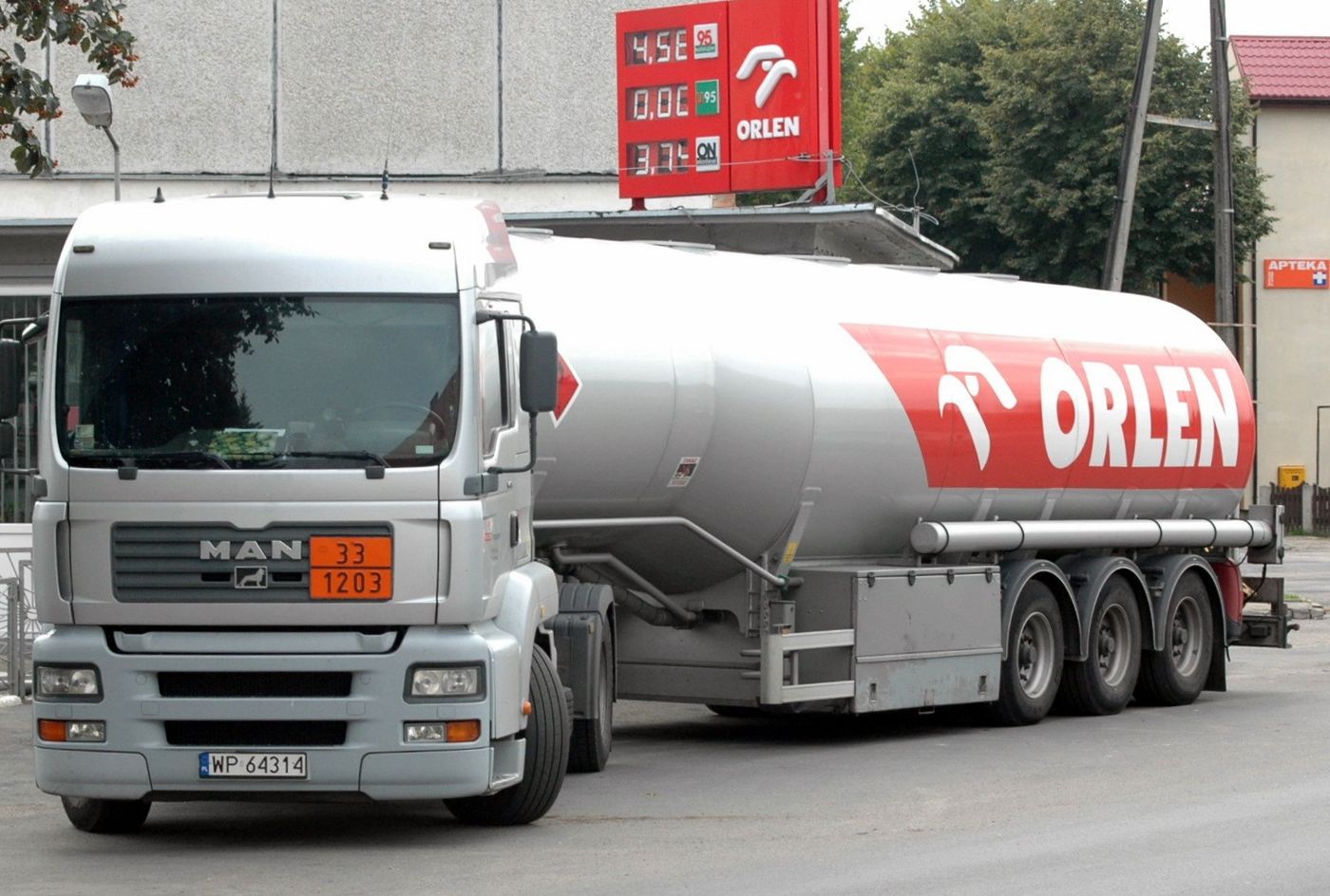 Silver and red tank semi-trailer pulled by a MAN TGA tractor unit, with an orange ADR plate reading 33 over 1203 on the cab front