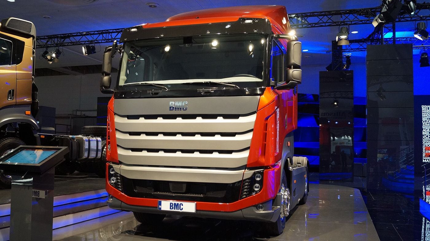 Orange BMC Tuğra 4x2 tractor unit viewed from the front, its large silver slatted grille and BMC badge prominent, on the BMC stand at the IAA 2018 commercial vehicle show