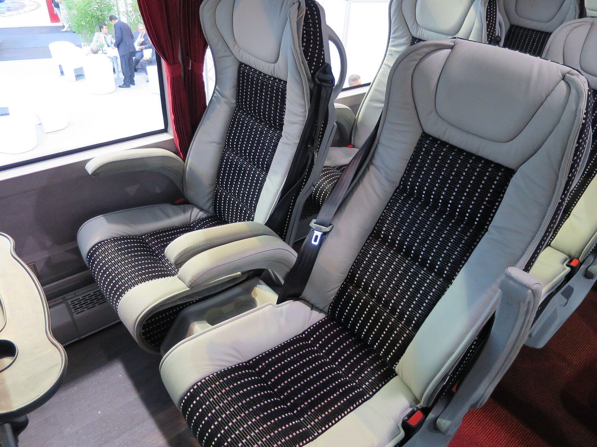Three-point safety belts fitted to reclining passenger seats inside a coach