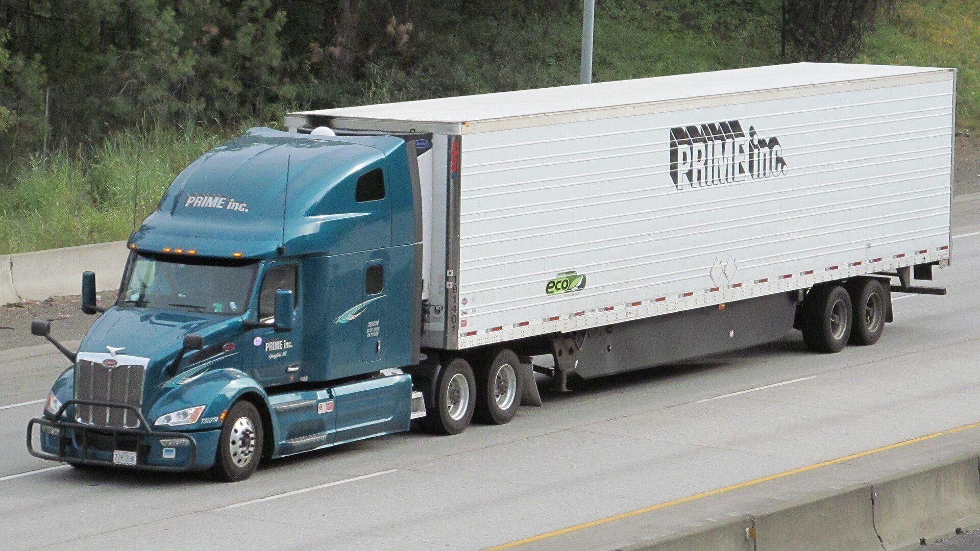 Teal Peterbilt tractor pulling a white Prime Inc. refrigerated semitrailer on Interstate 90 near Spokane, Washington