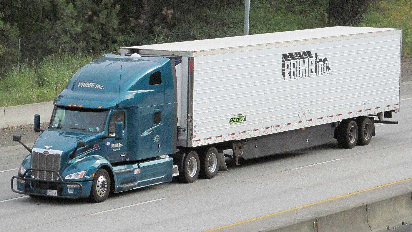 Teal Peterbilt tractor pulling a white Prime Inc. refrigerated semitrailer on Interstate 90 near Spokane, Washington
