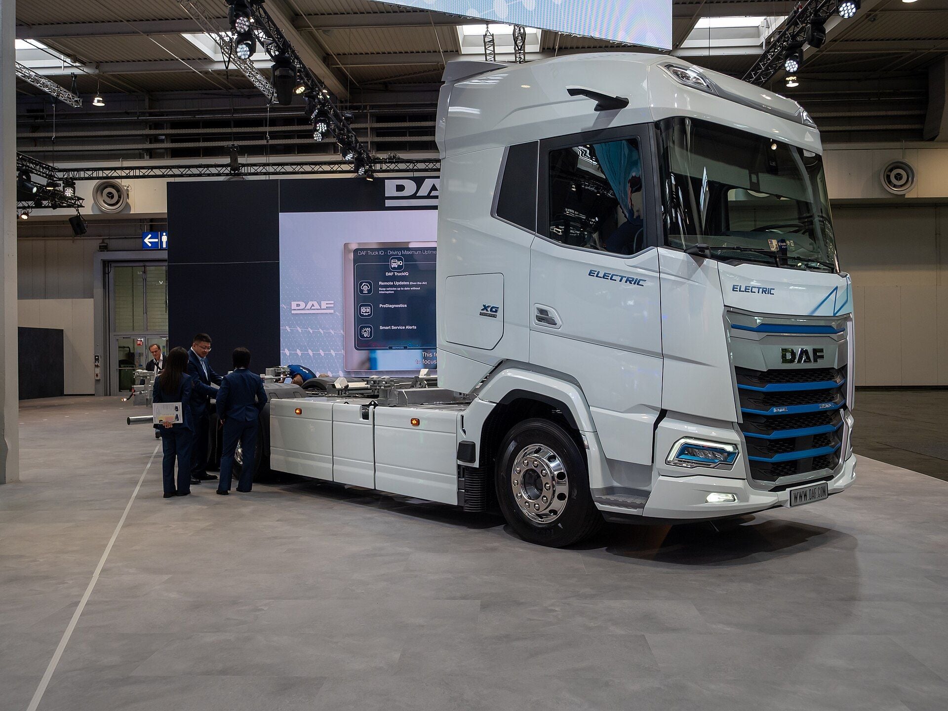 Tracteur routier DAF XG Electric blanc avec des touches bleues sur la calandre et l'inscription ELECTRIC sur la porte et à l'avant, sur le stand de DAF lors d'un salon professionnel
