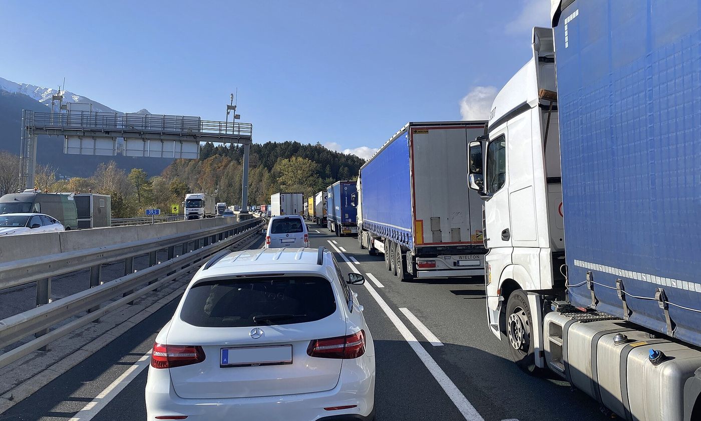 Stau auf der Inntal Autobahn A12 bei Wiesing in Tirol: eine Kolonne von Sattelzügen auf der rechten Spur, daneben Pkw, Blickrichtung Südwesten