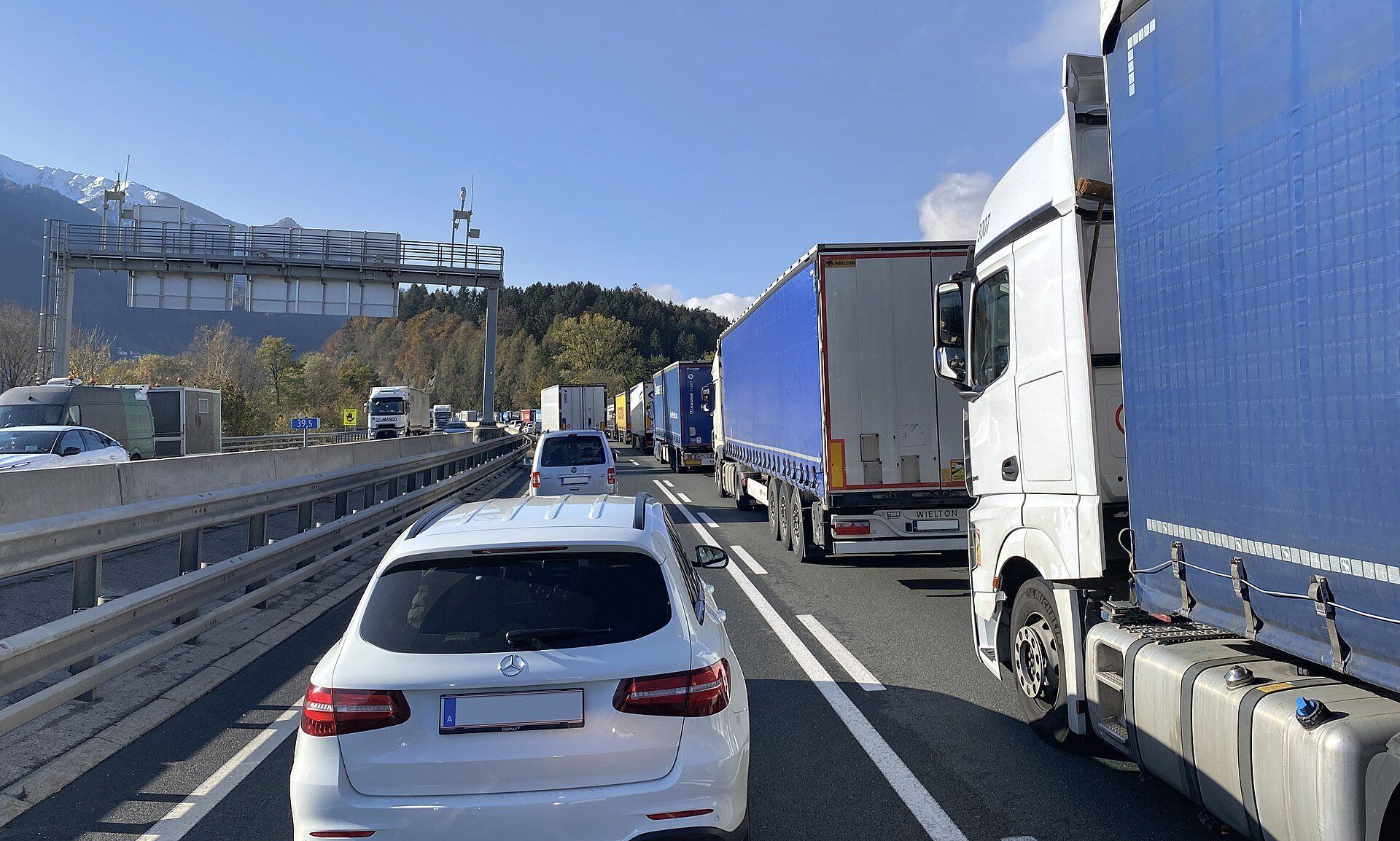 Stau auf der Inntal Autobahn A12 bei Wiesing in Tirol: eine Kolonne von Sattelzügen auf der rechten Spur, daneben Pkw, Blickrichtung Südwesten