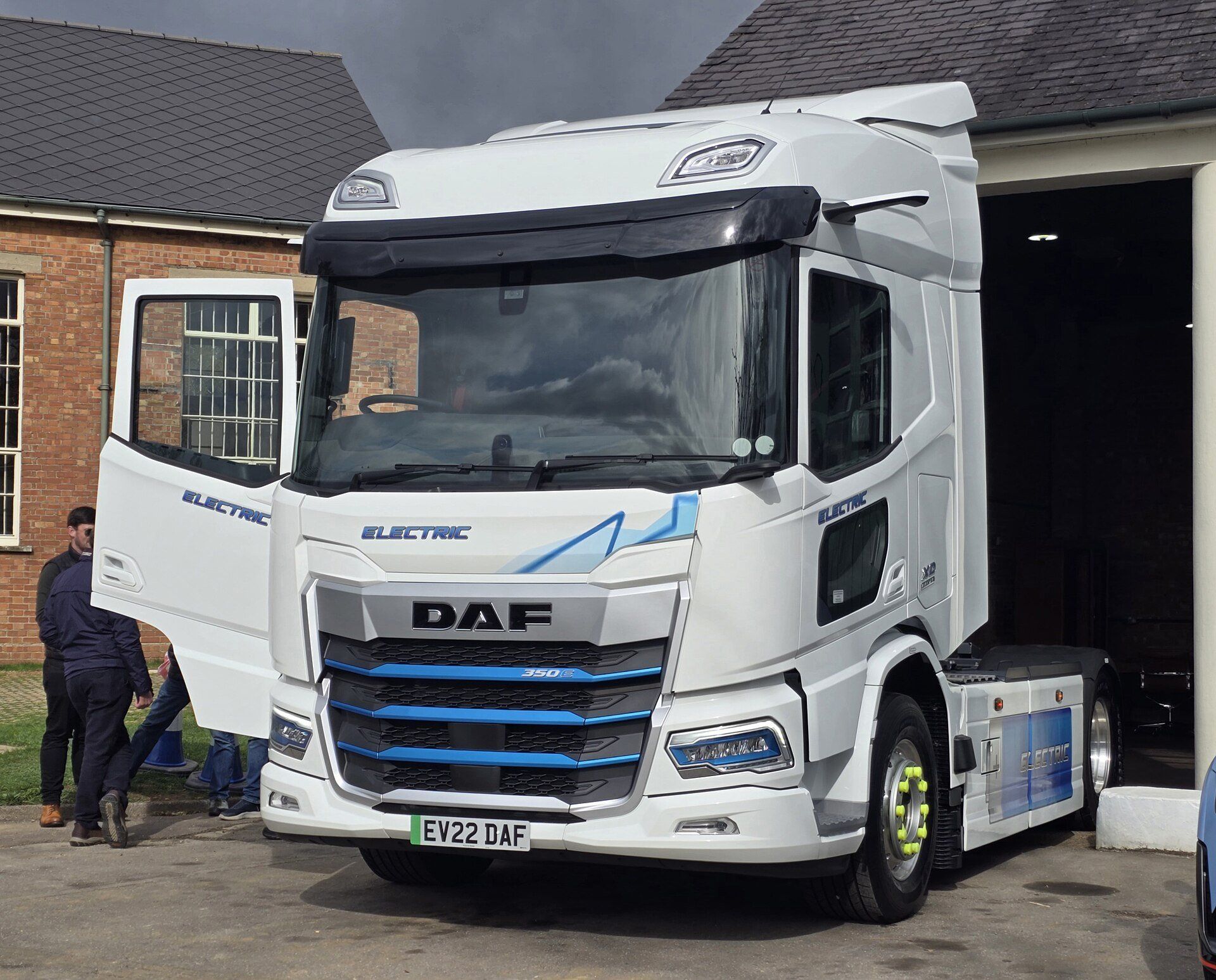 White DAF XD Electric tractor unit with the cab door open, parked outside a brick building