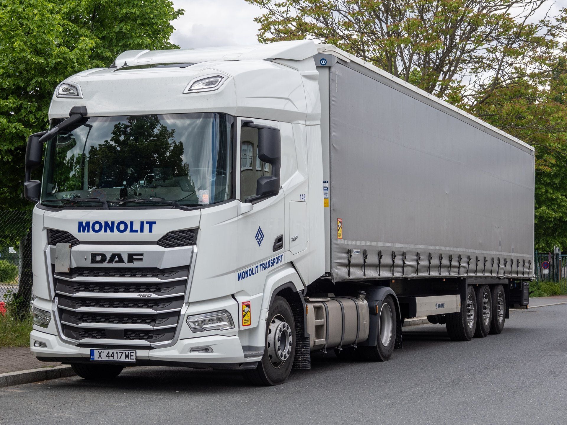 White DAF XF 480 tractor unit with a grey curtain-sided semi-trailer parked at a kerb in Berlin