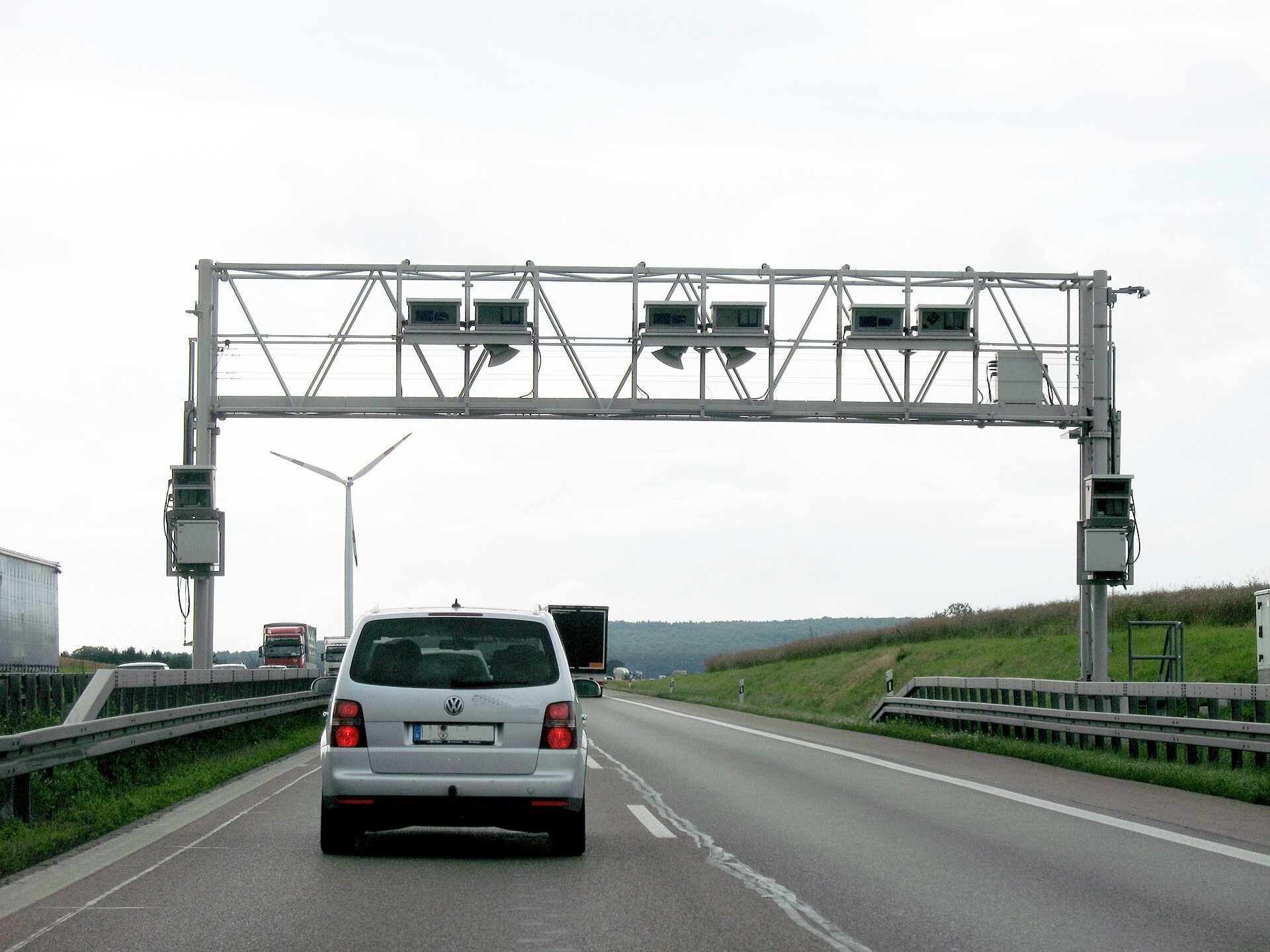 Pórtico de control de Toll Collect sobre una calzada de una autopista alemana, con camiones aproximándose por el carril izquierdo