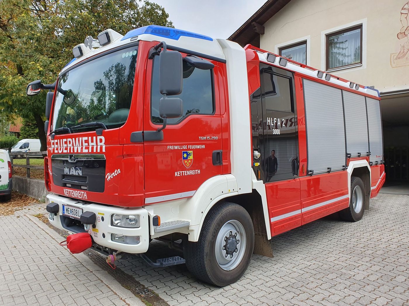 Red and white HLF 2 rescue and firefighting vehicle of the Kettenreith volunteer fire brigade in Austria, built on a MAN TGM 15.290 4x4 chassis with a crew cab and roller-shutter lockers