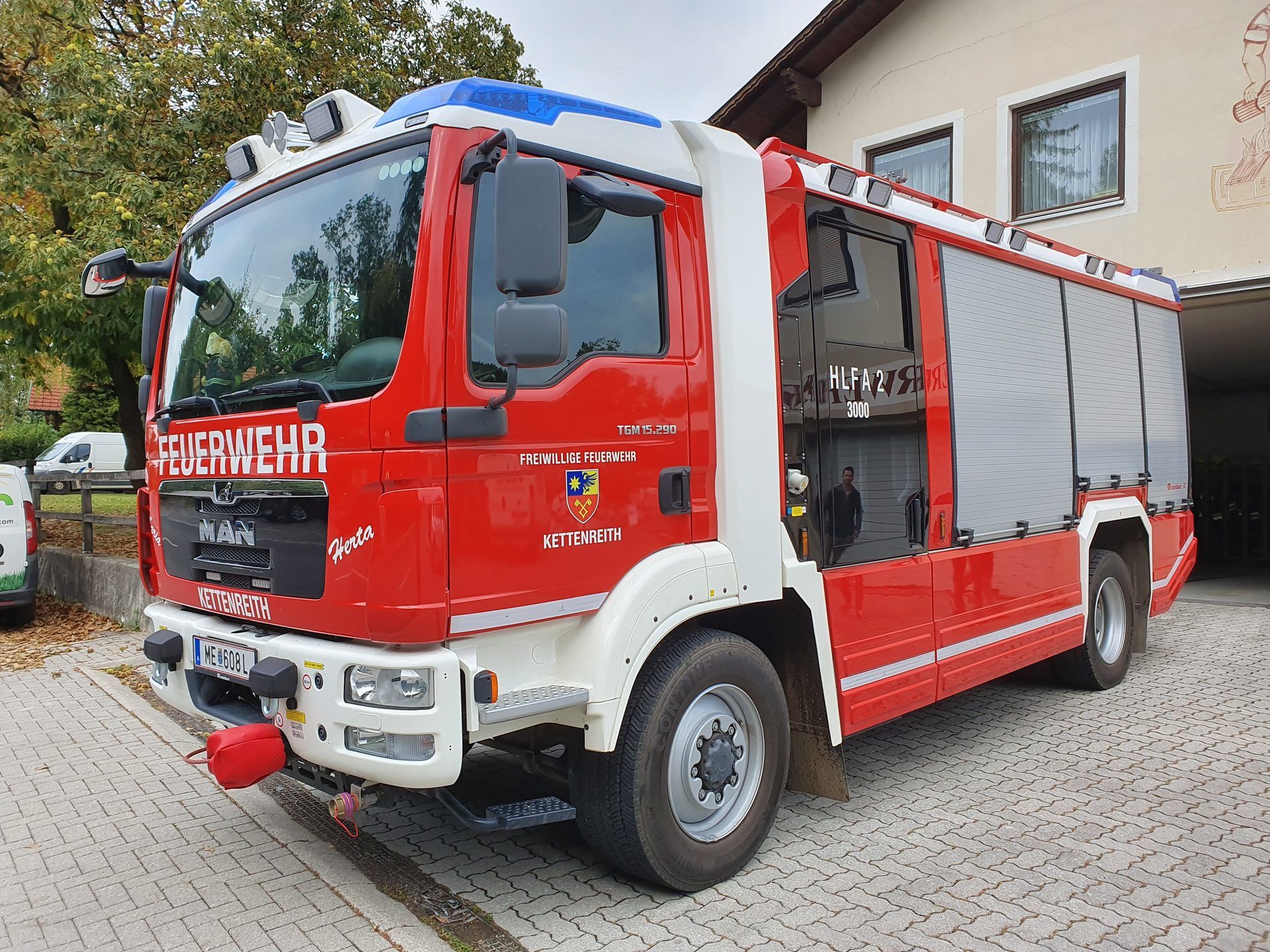 Red and white HLF 2 rescue and firefighting vehicle of the Kettenreith volunteer fire brigade in Austria, built on a MAN TGM 15.290 4x4 chassis with a crew cab and roller-shutter lockers