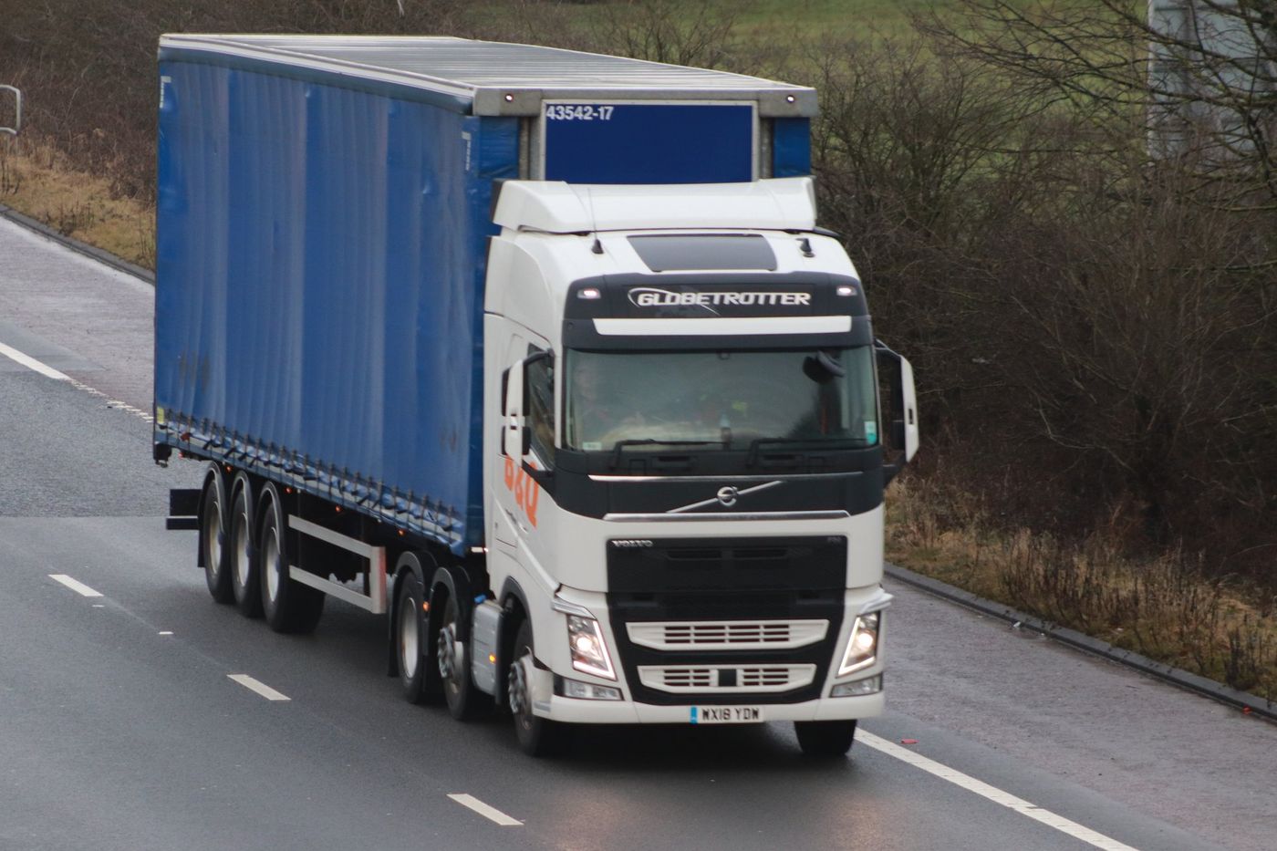 Volvo FH tractor unit with a curtain-sided semi-trailer on a road in Lancashire, England