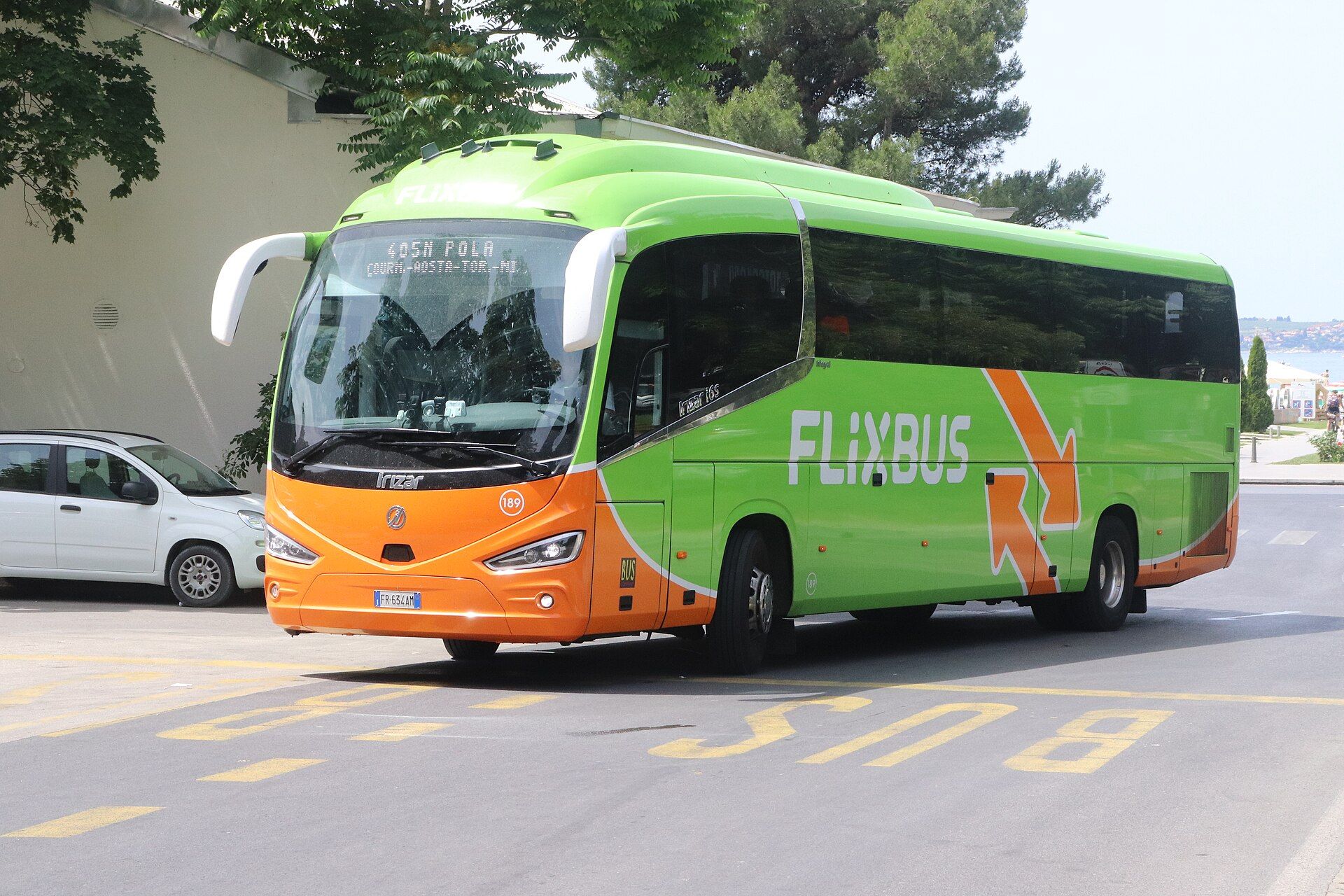 Green and orange FlixBus-liveried Irizar i6S integral coach at a bus stop in Portoroz, Slovenia, seen from the front nearside