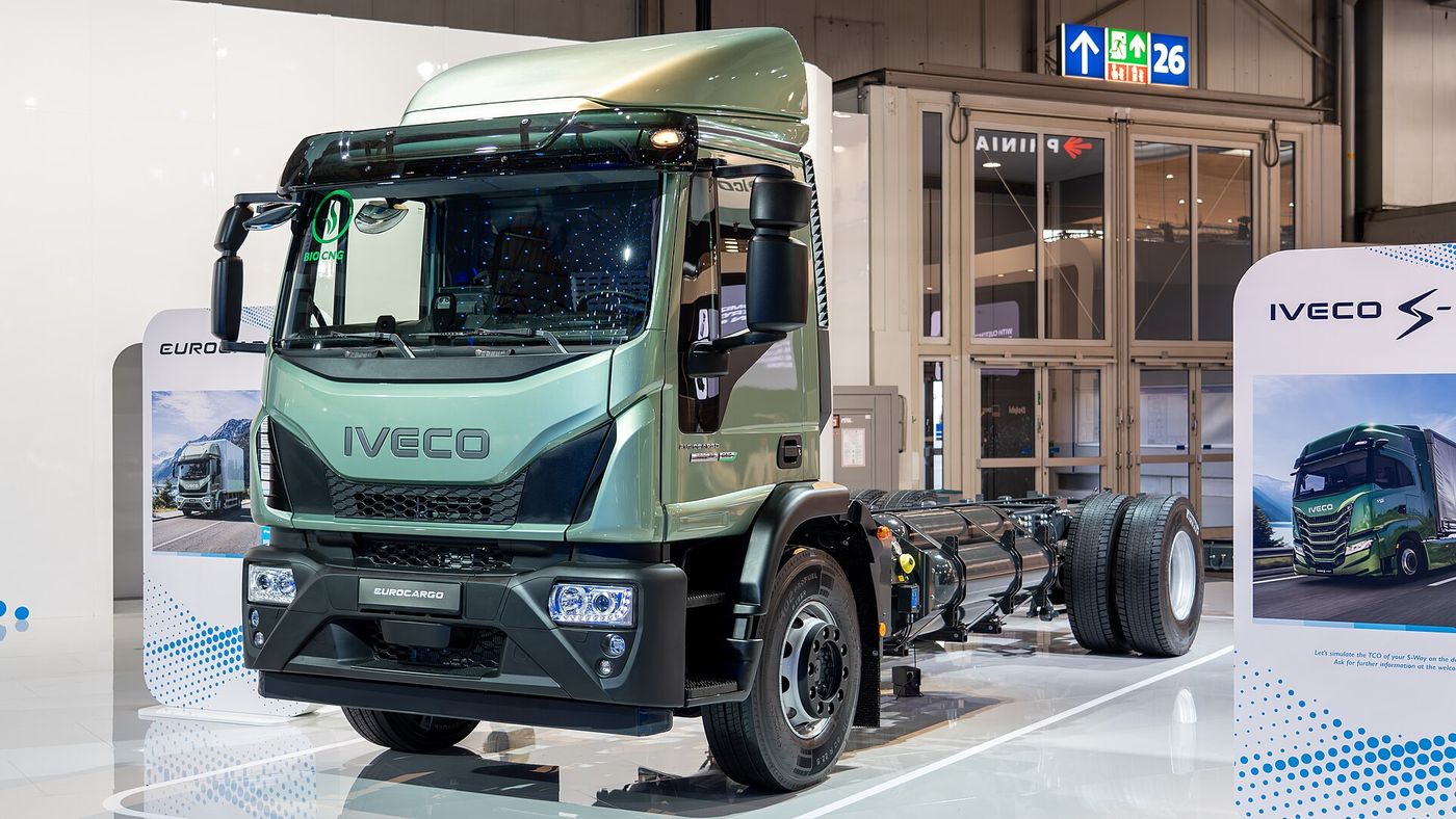 Zielone podwozie z kabiną Iveco Eurocargo CNG z naklejką bio-CNG na przedniej szybie i butlami gazowymi wzdłuż odsłoniętej ramy, na stoisku IVECO podczas targów IAA Transportation 2024