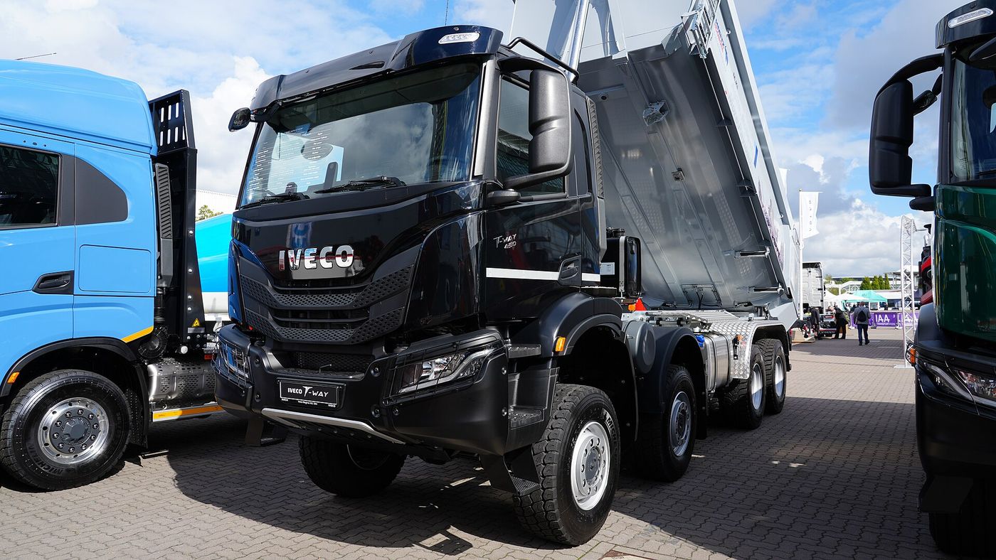 Czarna czteroosiowa wywrotka Iveco T-Way z podniesioną skrzynią ładunkową, wystawiona na targach IAA Transportation 2022
