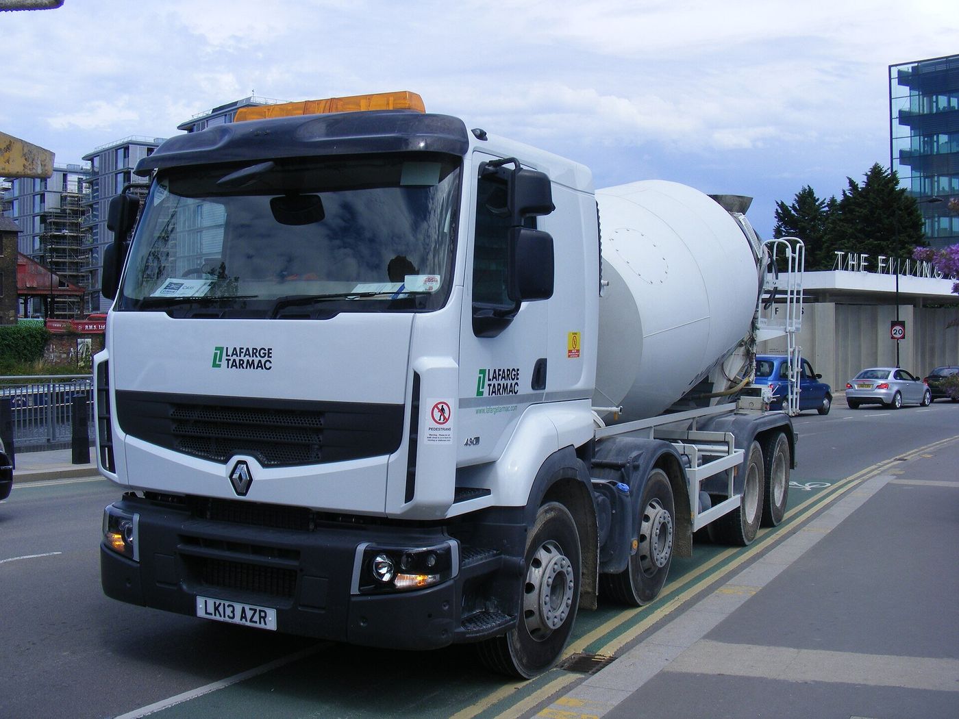 White Renault eight-wheeled concrete mixer lorry seen from the front left on a London street beside a green cycle-lane marking