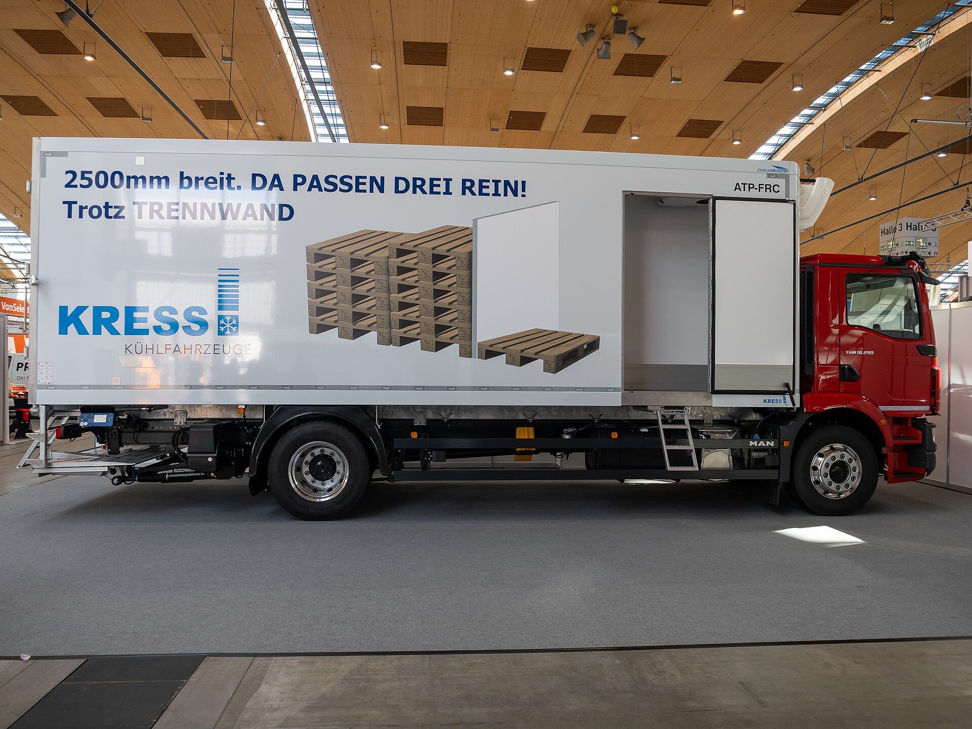 Red MAN TGM 18.290 two-axle rigid with a white refrigerated box body, a side door open and a tail lift, seen side-on at the Nufam 2025 trade fair in Rheinstetten