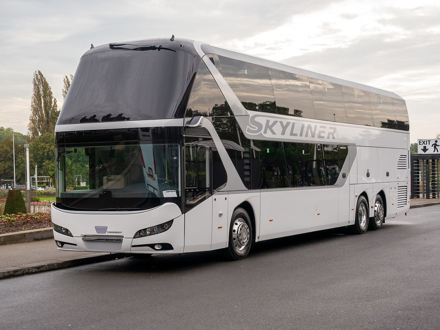 White Neoplan Skyliner three-axle double-deck coach with grey SKYLINER lettering and a split windscreen, front three-quarter view, parked outdoors at Busworld Europe 2023 in Brussels