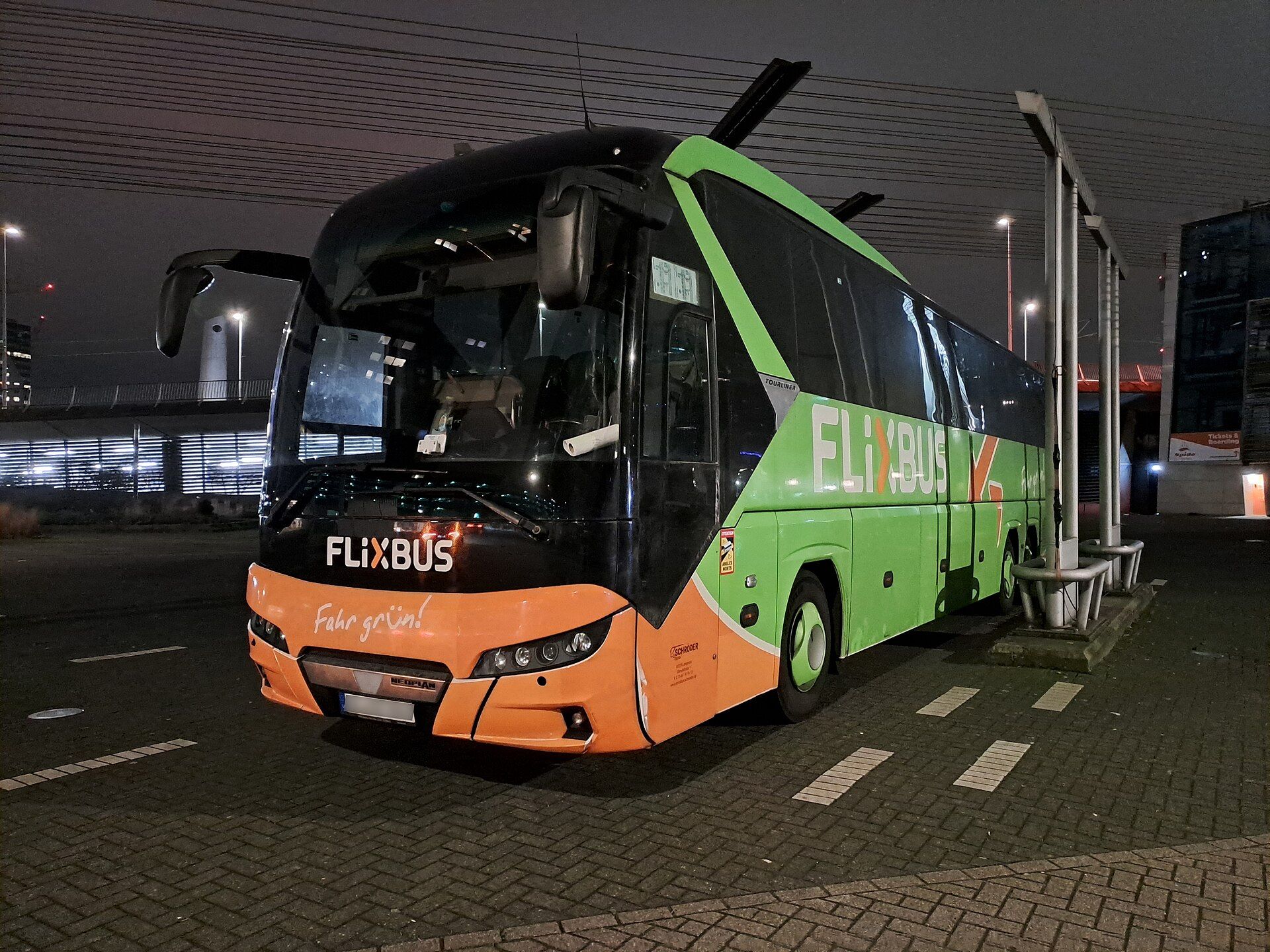 Neoplan Tourliner in green and orange FlixBus livery parked at night at the coach station in Rotterdam