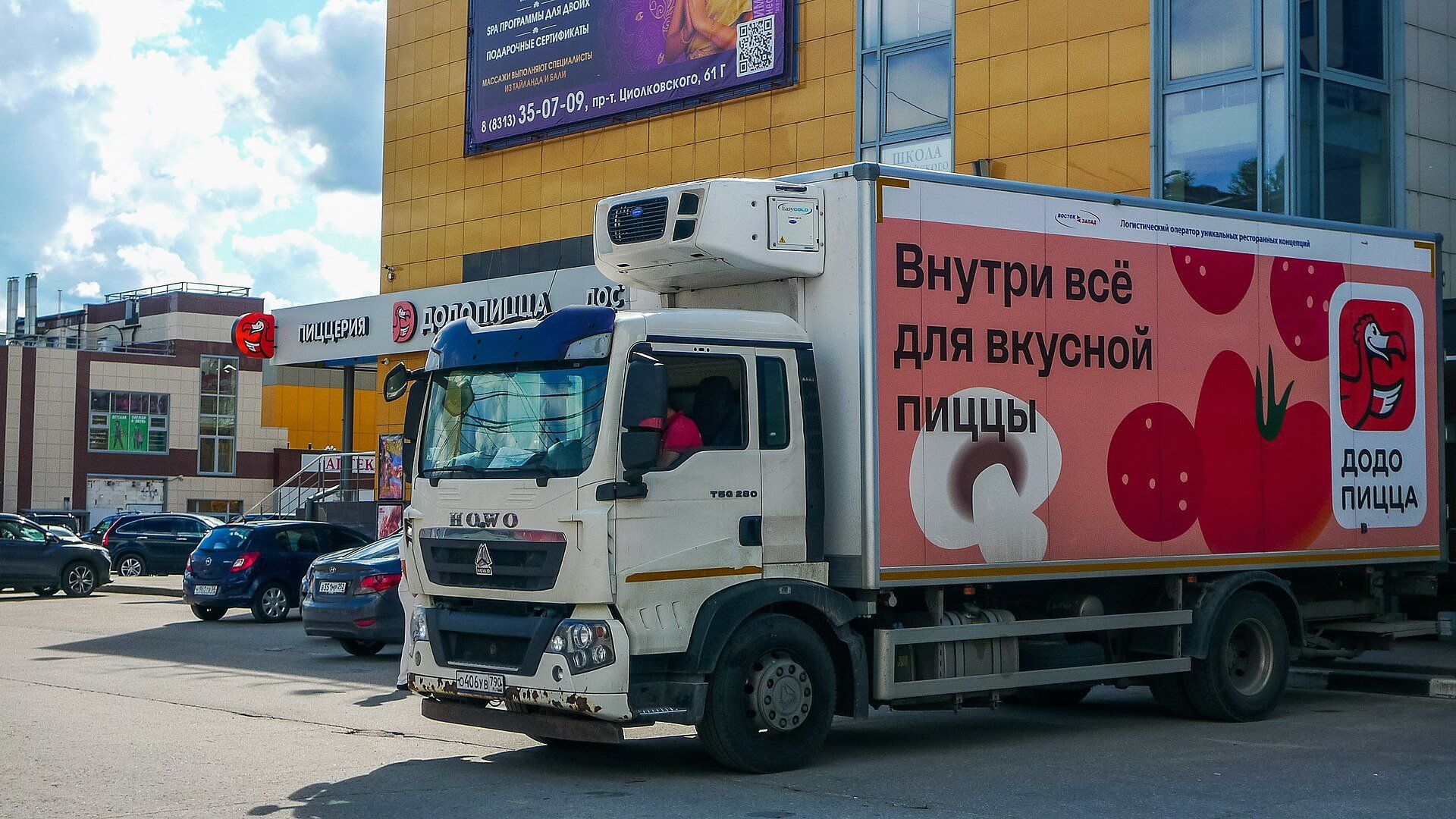 Рефрижераторный грузовик HOWO T5G с фургоном логистического оператора у торгового центра в Дзержинске, за рулём водитель