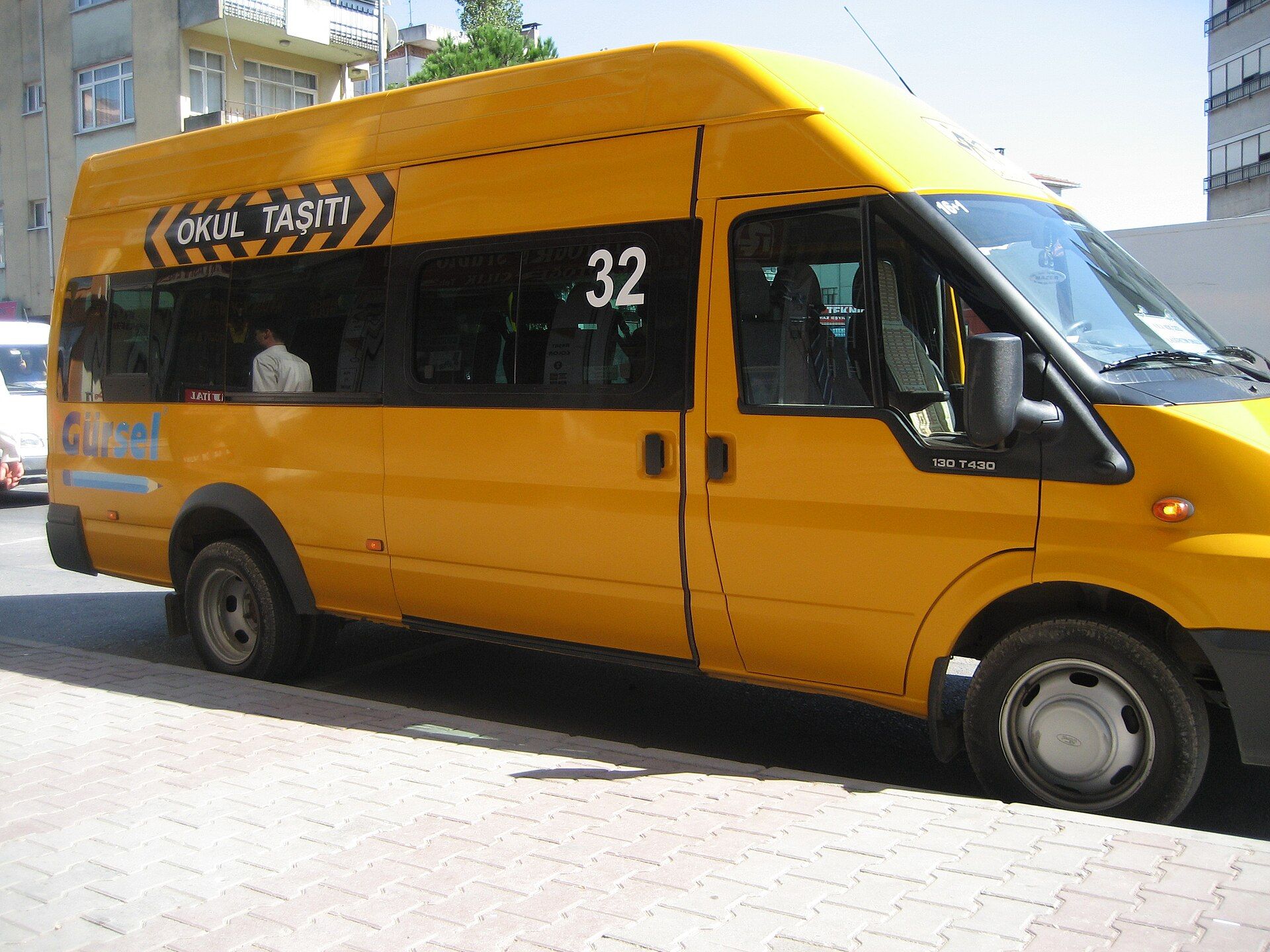 İstanbul'da, camların üzerinde OKUL TAŞITI okul aracı bandı taşıyan sarı bir Ford Transit minibüs