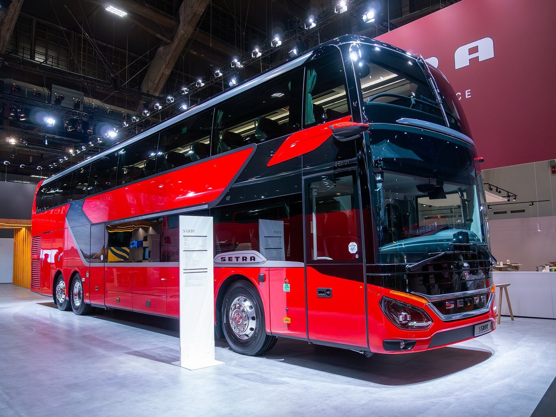 Red and black Setra TopClass S 531 DT three-axle double-decker coach on the Setra stand at Busworld Europe 2025 in Brussels, seen from the front right
