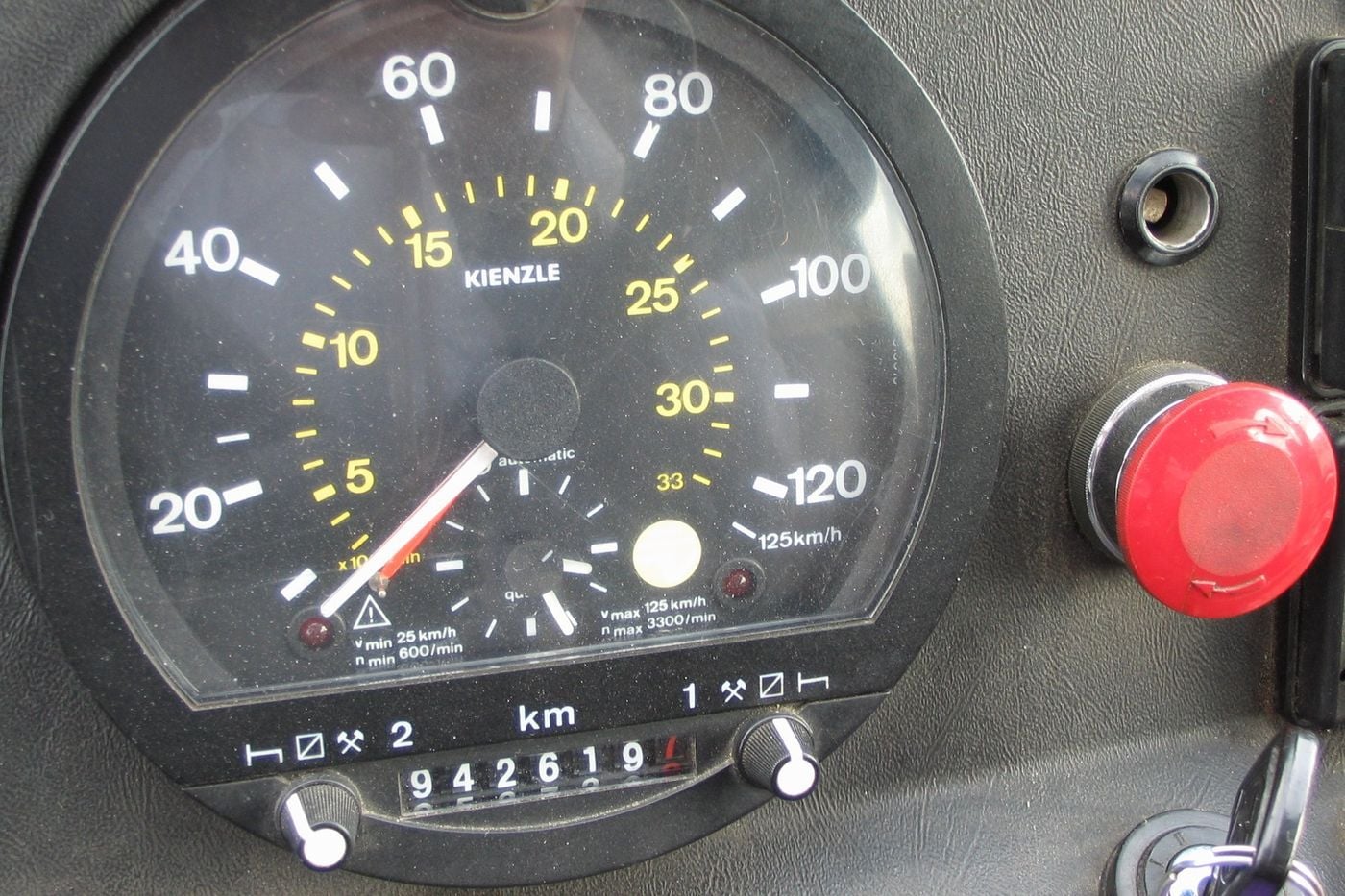 Analogue paper-disc Kienzle tachograph in the dashboard of a Setra 210 HD bus, with two rotary selector switches marked 2 and 1, each beside a row of three printed symbols