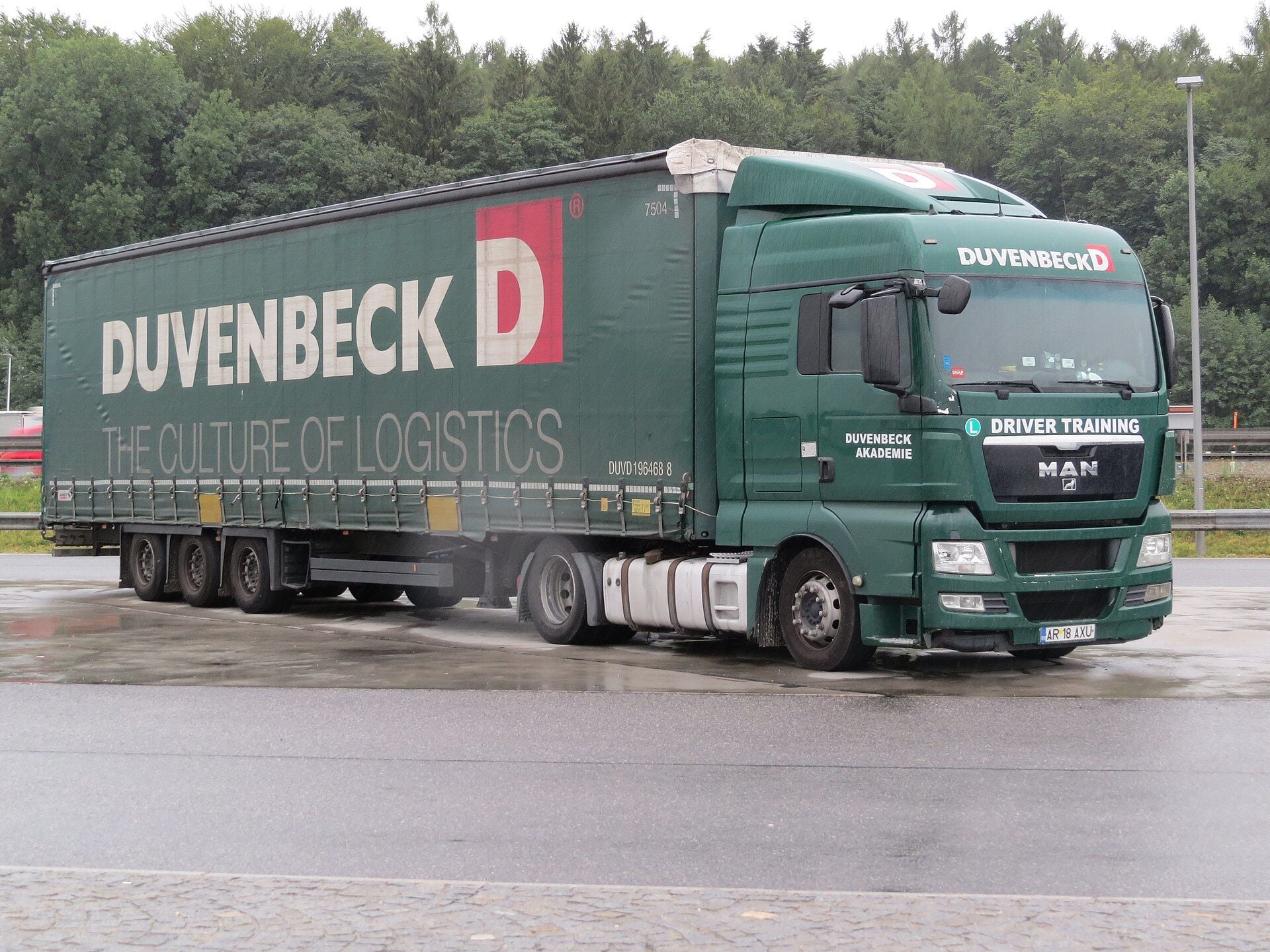 Green MAN tractor unit and three-axle curtainsider semi-trailer marked Driver Training and Duvenbeck Akademie, with an L sign, at the Kirchstetten rest area in Austria