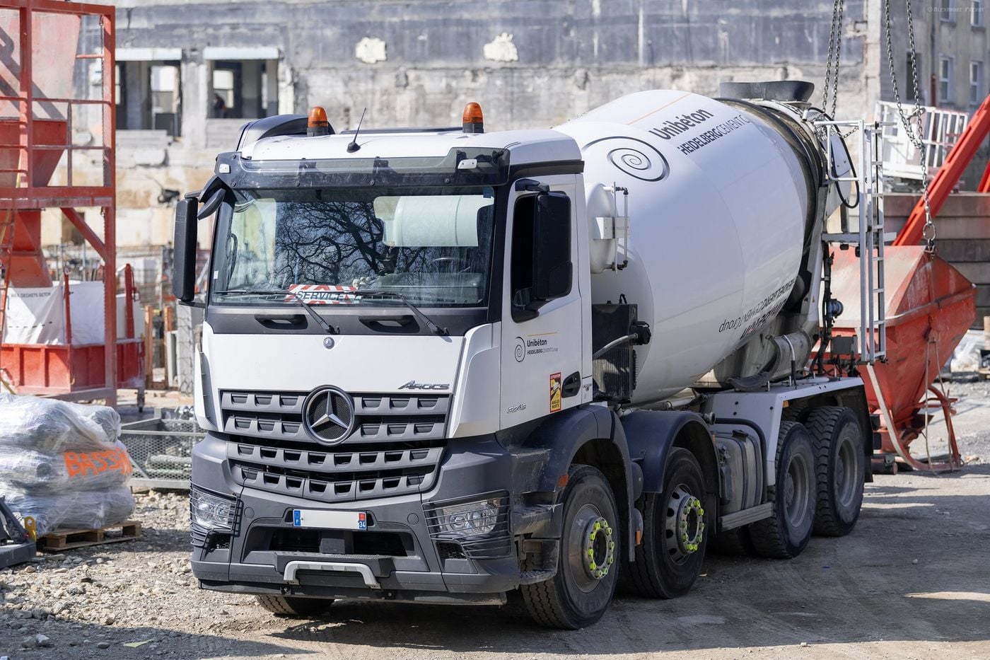 White Mercedes-Benz Arocs 8x4 truck mixer with a Unibéton drum on the Grand Nancy Thermal building site in Nancy, France, in April 2021